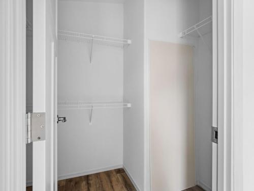 A white closet with a wooden floor.