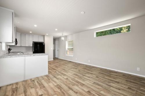 An empty kitchen with wood floors and white walls.